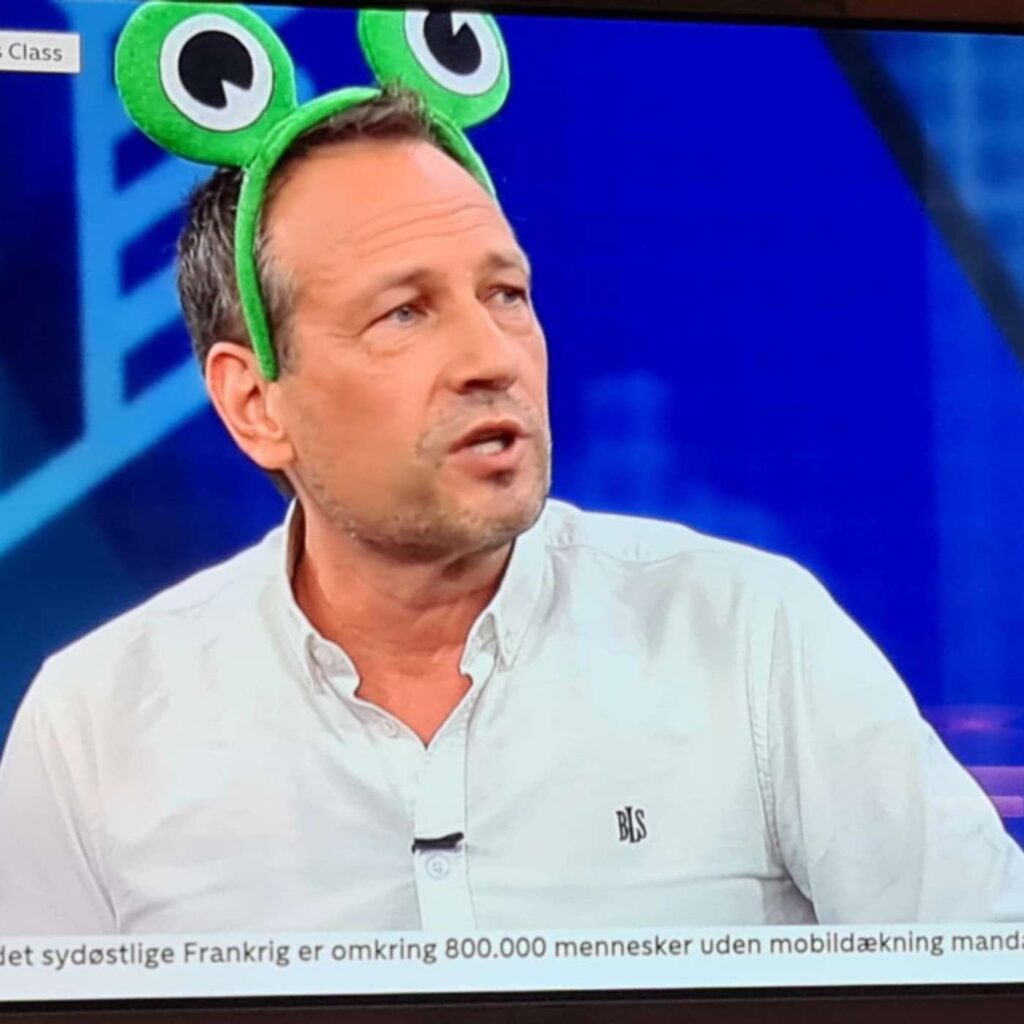Martin Thorborg p&aring; en tv-sk&aelig;rm med store gr&oslash;nne &oslash;jne p&aring; en h&aring;rb&oslash;jle.
