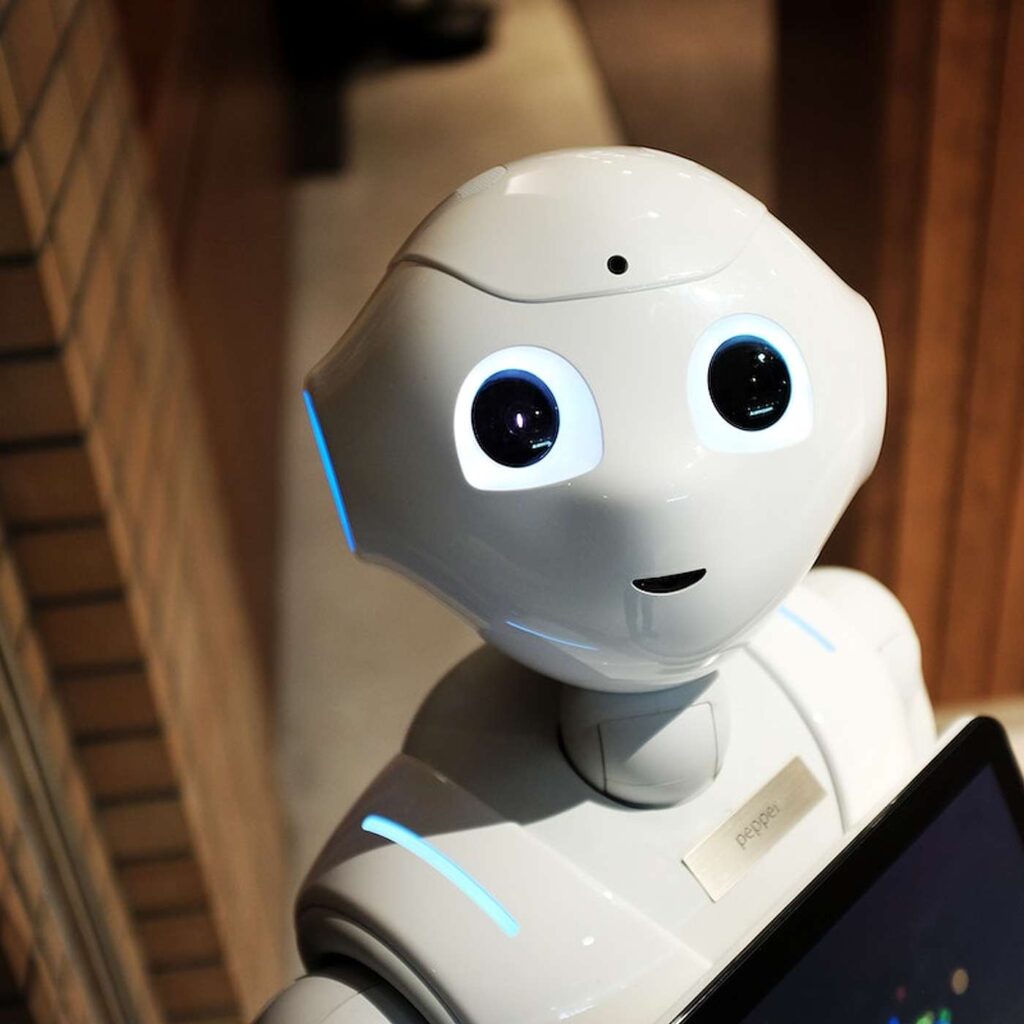En hvid robot med store sorte &oslash;jne og en sk&aelig;rm foran kroppen.