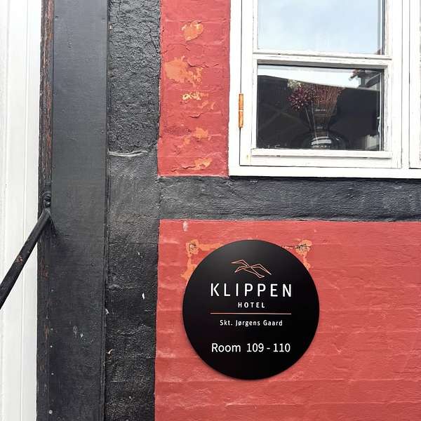 Skilt med Klippen Hotel Skt. J&oslash;rgensgaard p&aring; en r&oslash;d og sort facade.