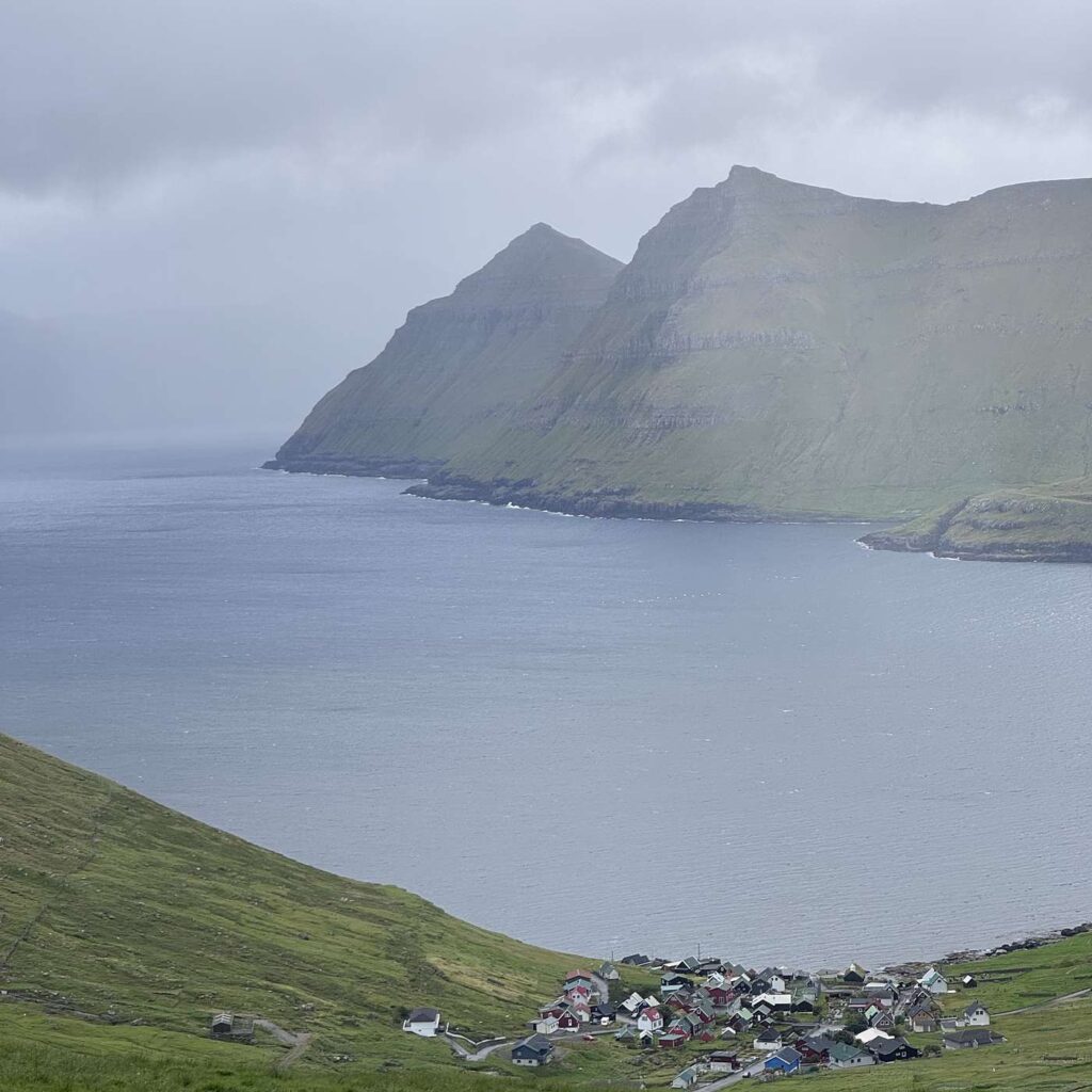Grønne fjelde, en kystbygd og havet på Færøerne.